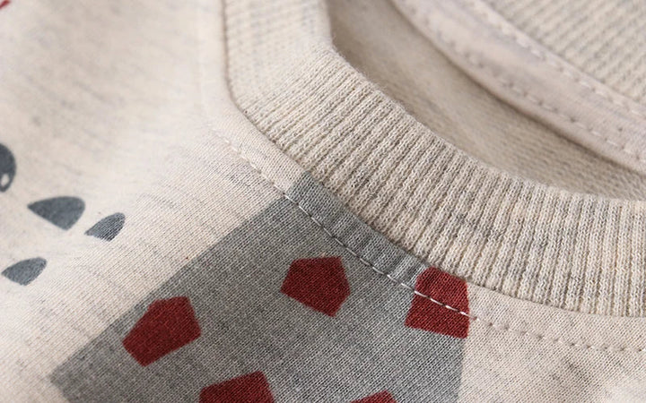 Close-up of neckline stitching and ribbing on the beige printed sweatshirt