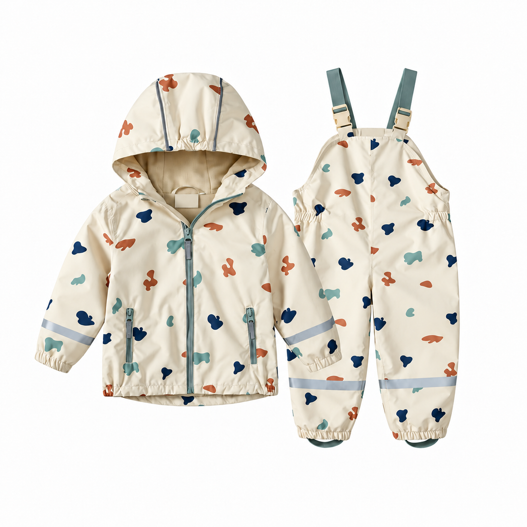 Cream hooded rain jacket and matching bib-style pants with a colorful abstract print.