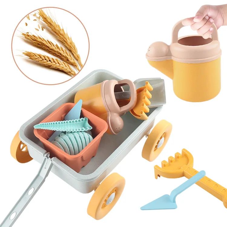 Blue beach wagon holding buckets and molds beside a watering can, rake, and shovel