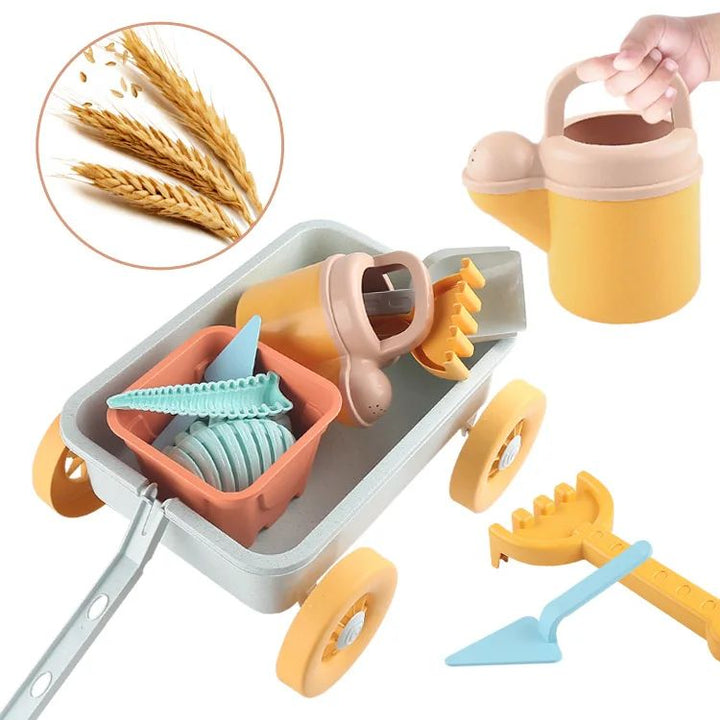Blue beach wagon holding buckets and molds beside a watering can, rake, and shovel