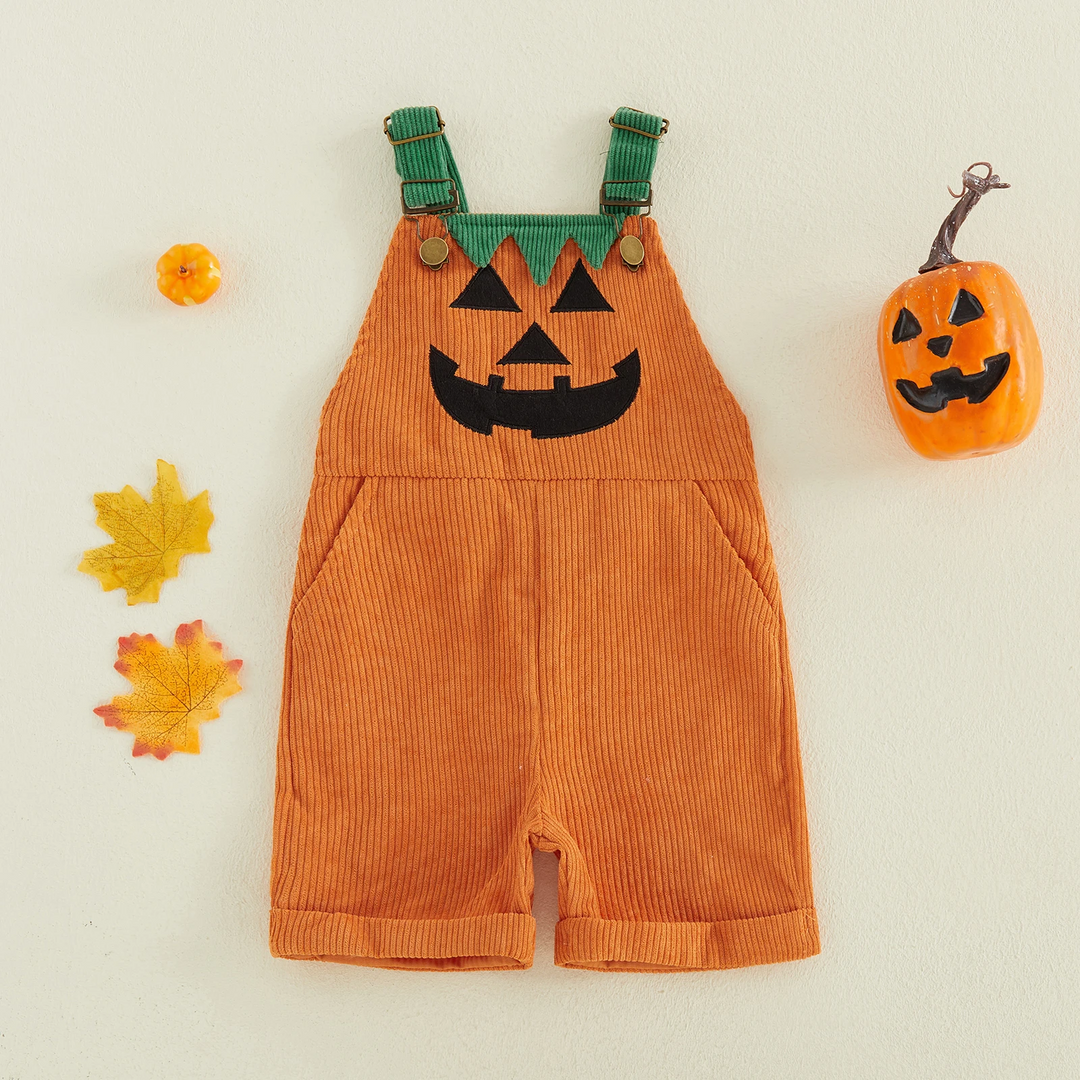 Orange ribbed pumpkin overalls arranged with fall leaves and a jack-o&