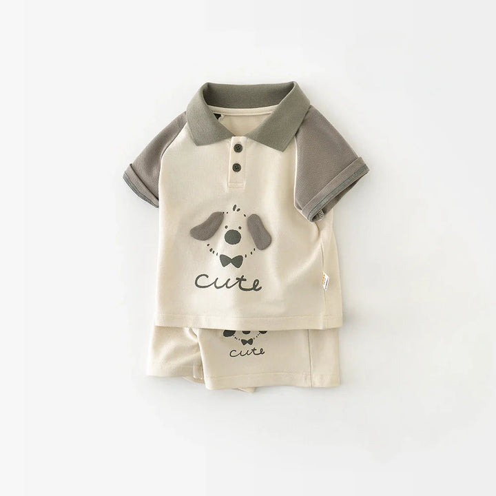 Ivory baby polo with gray sleeves and a puppy print, shown over folded matching shorts