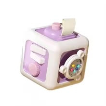 Purple and white activity cube with a top pull tab, turning knob, and bead spinner