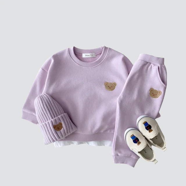 Purple bear-patch sweatshirt and pants styled with a matching knit hat and white slip-on shoes
