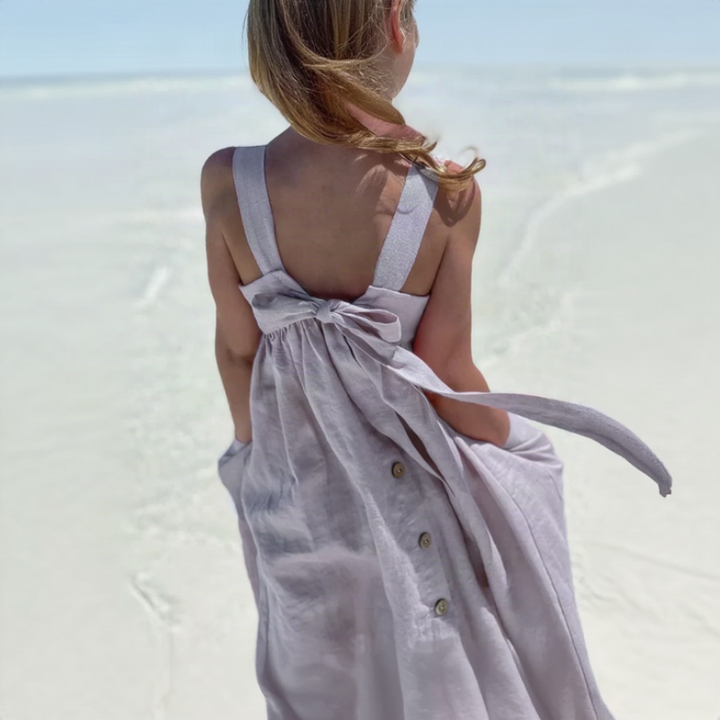 Purple cotton dress with a back bow, worn at the beach