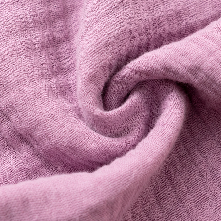 Purple cotton fabric gathered to show its crinkled texture