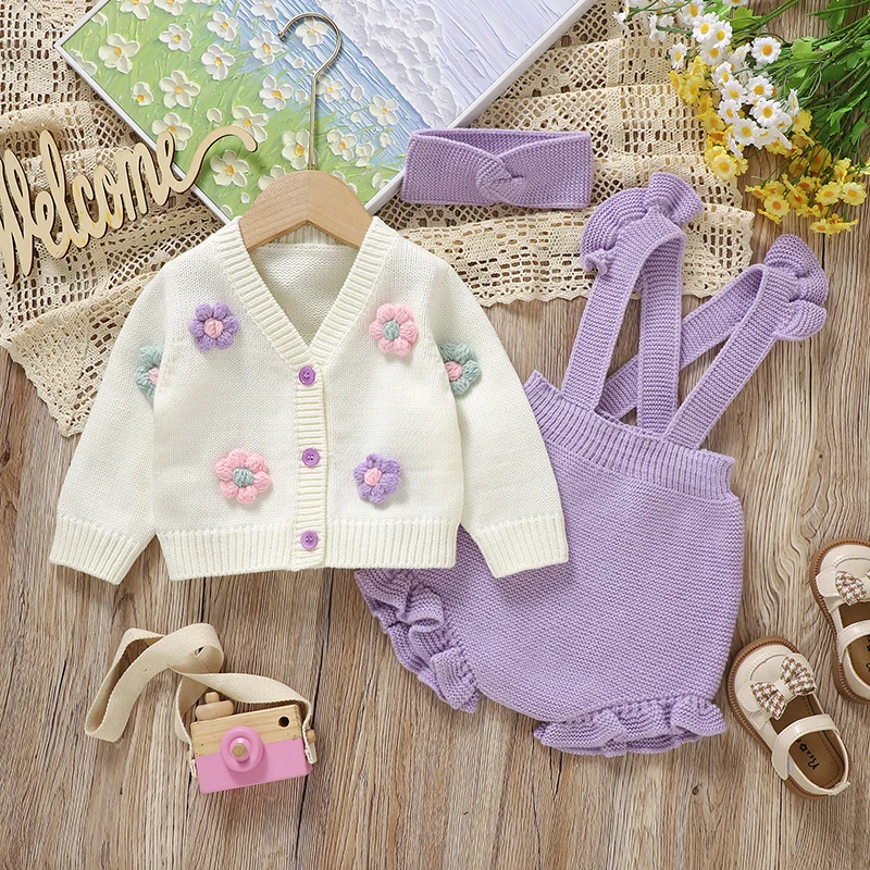 Purple baby outfit with a white floral cardigan, ruffled overalls and coordinating headband