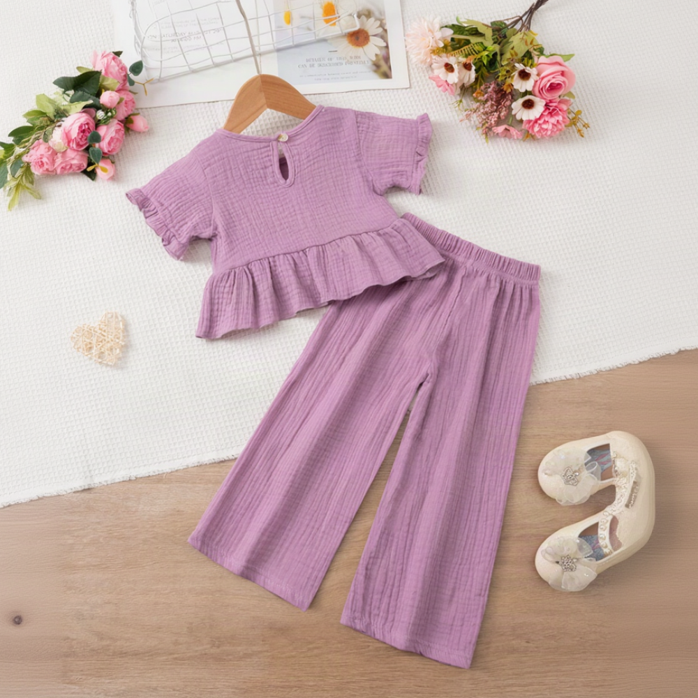 Back view of the purple ruffle top with matching wide-leg pants laid out below