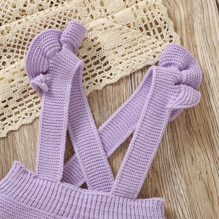 Close-up of purple knit overall straps with ruffled trim