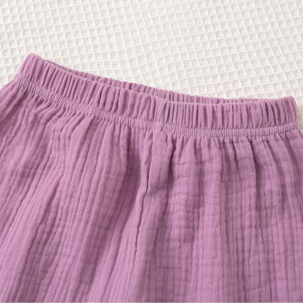 Close-up of the gathered elastic waistband on the purple pants