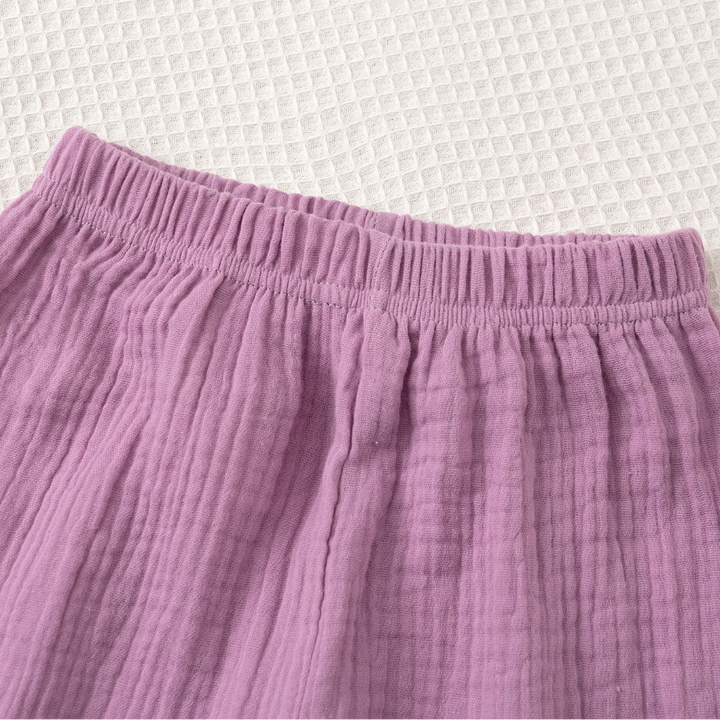 Close-up of the gathered elastic waistband on the purple pants