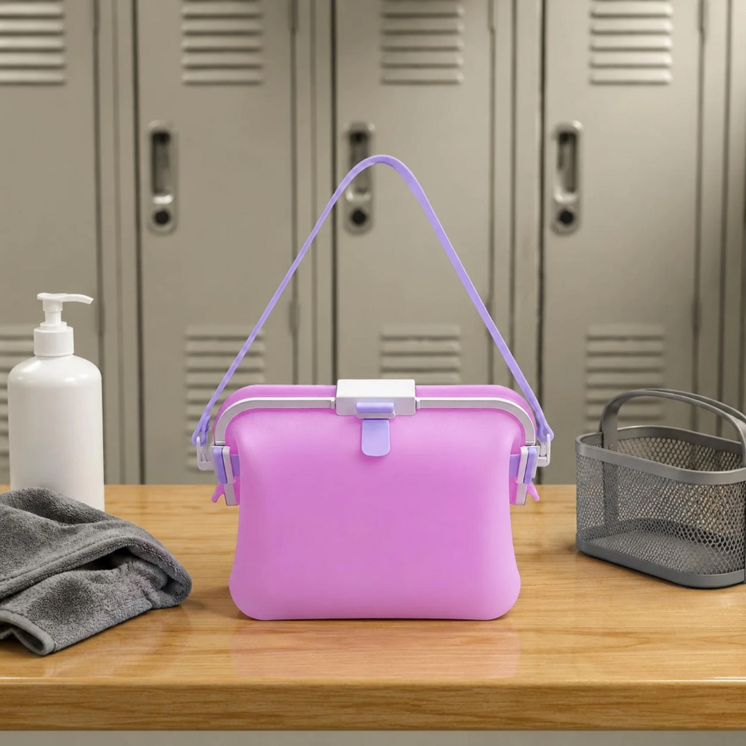 Purple silicone shoulder bag on a locker-room bench beside a towel and bottle.