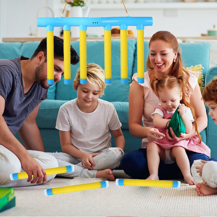 Family playing with a blue-and-yellow stick-catching game in a living room