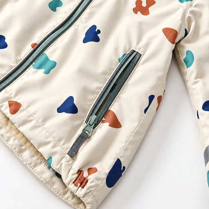 Zippered pocket and gathered lower hem on the cream printed rain jacket.