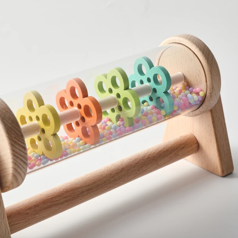Close-up of colorful wheels and small beads inside the wooden rain toy&