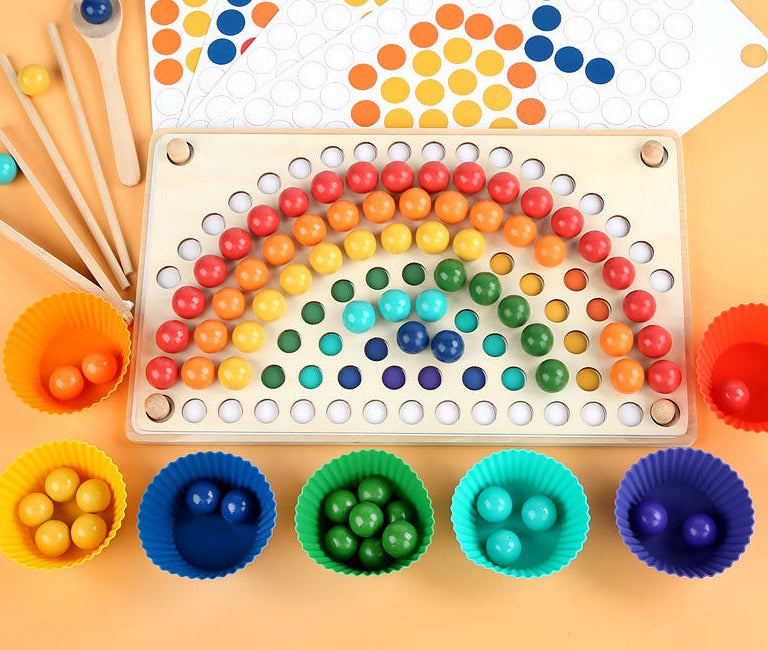 Wooden bead board with a rainbow pattern, colored sorting cups, pattern sheets, and wooden tools