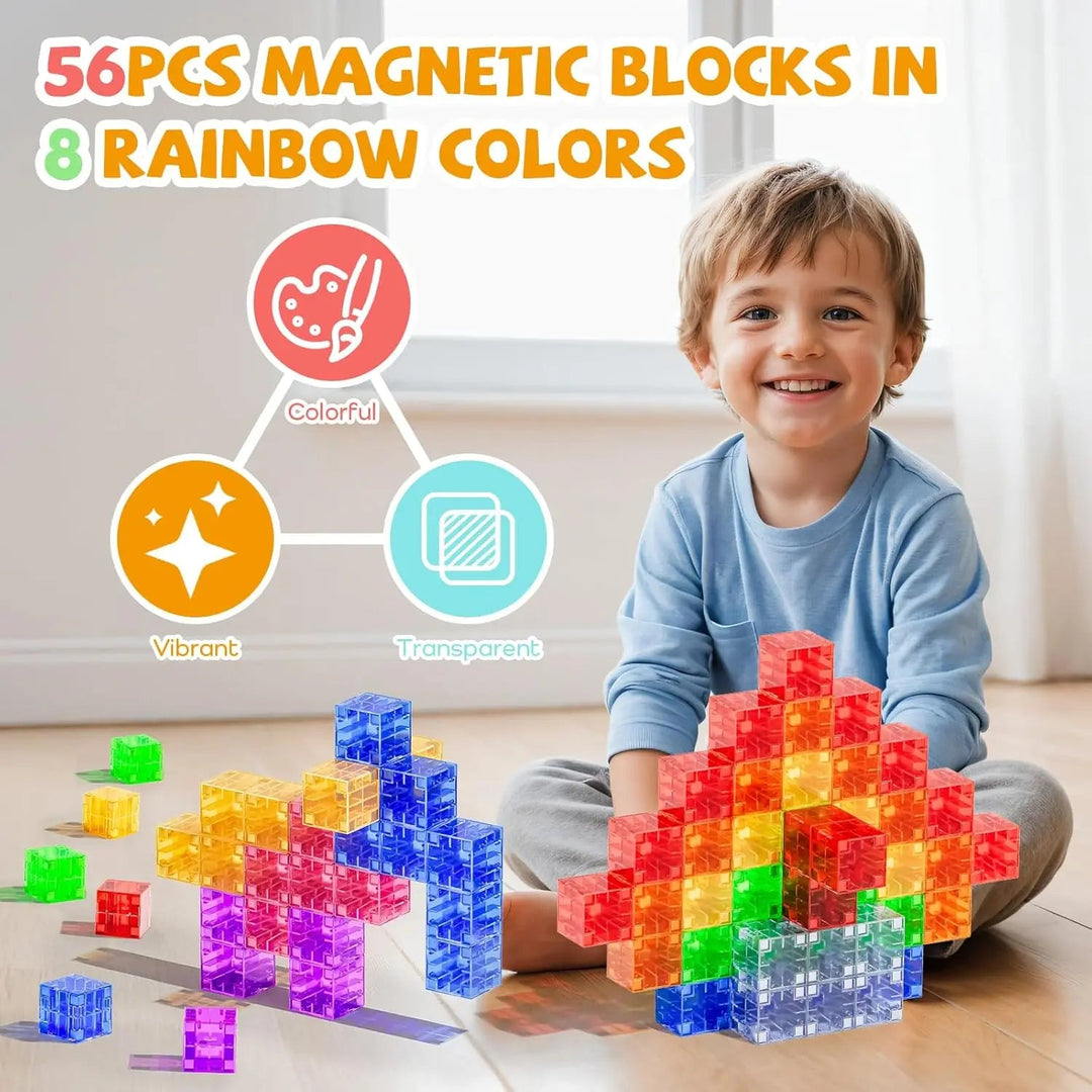 Child sitting behind rainbow magnetic cube structures with loose blocks nearby.