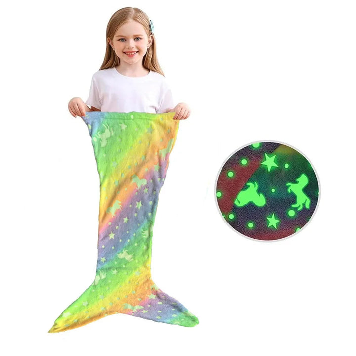 Child holding a rainbow mermaid sleeping bag without side fins beside a close-up of its glowing print.