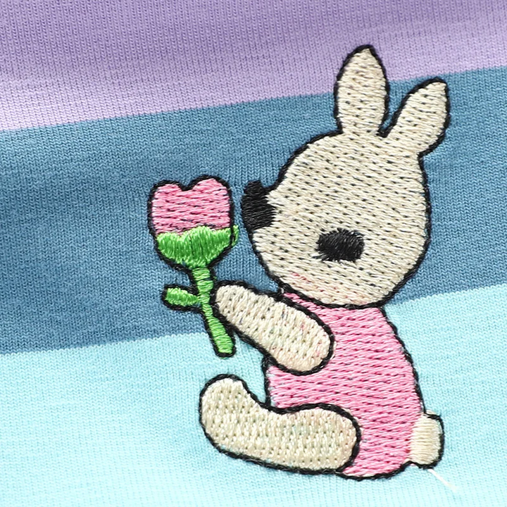 Embroidered bunny holding a flower on rainbow-striped dress fabric