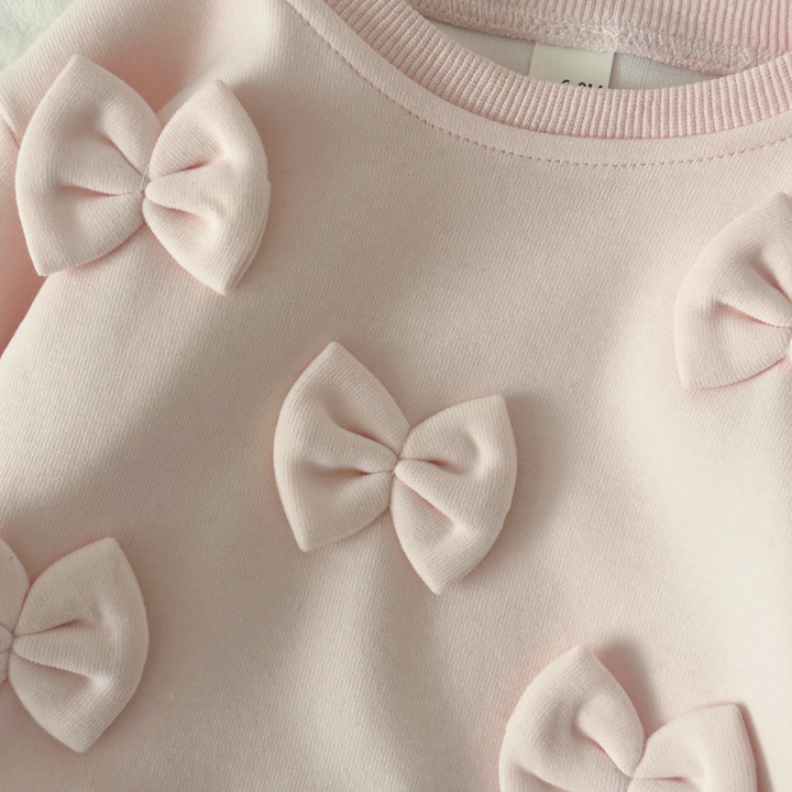 Close-up of raised pink bows and the sweater&