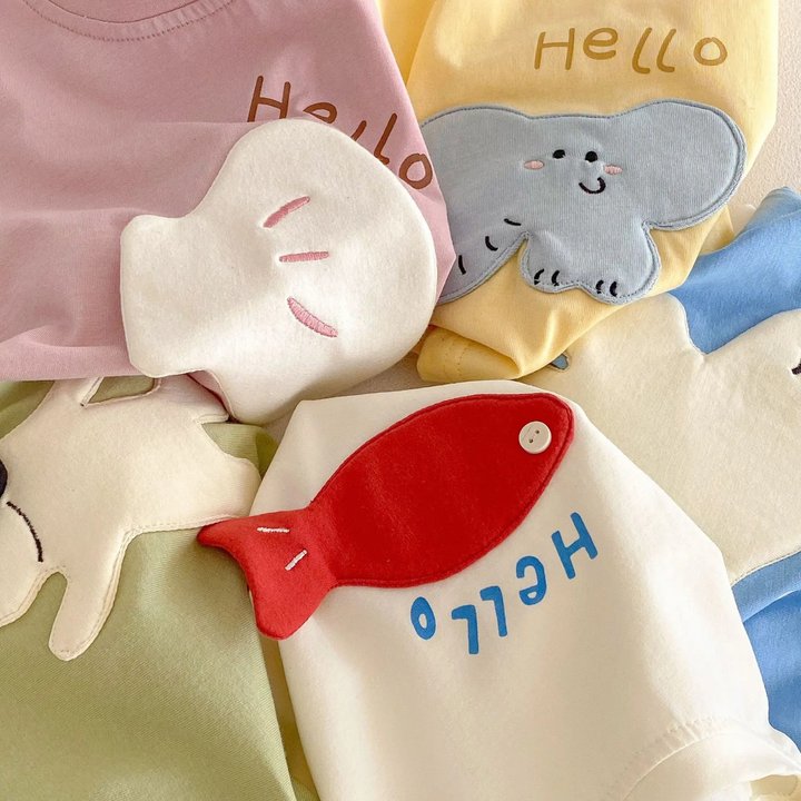 Close-up of raised cartoon patches on pink, yellow, beige, green, and blue T-shirts