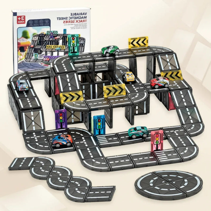 Elevated magnetic road layout with toy cars, traffic signs, and loose road tiles beside its box
