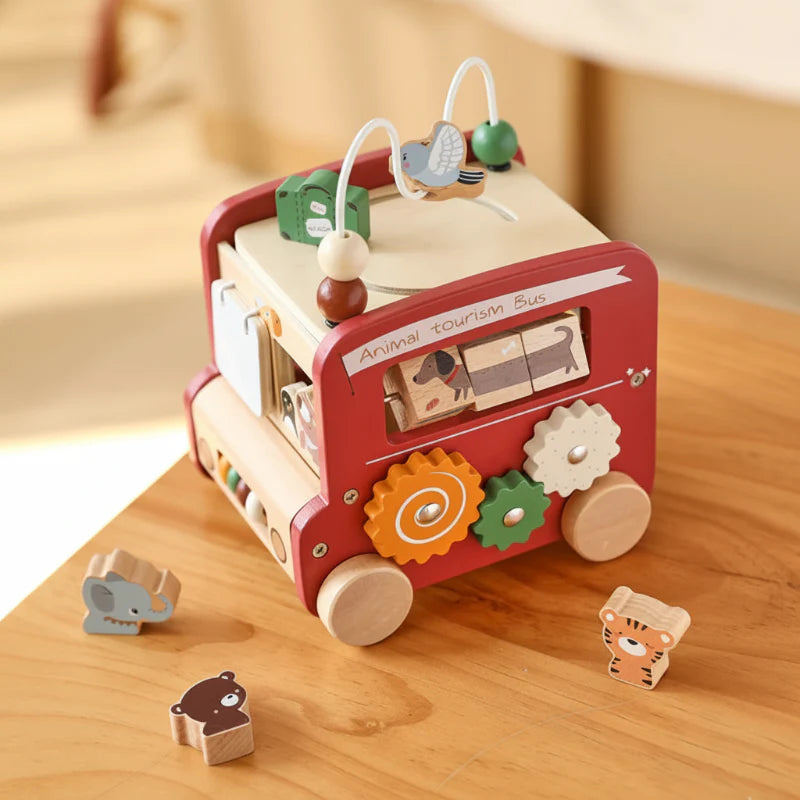 Red wooden activity bus on a table with three animal-shaped blocks