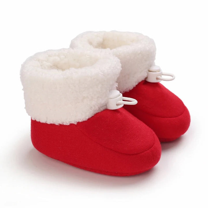 Red baby winter boots standing side by side with white cuffs and toggles