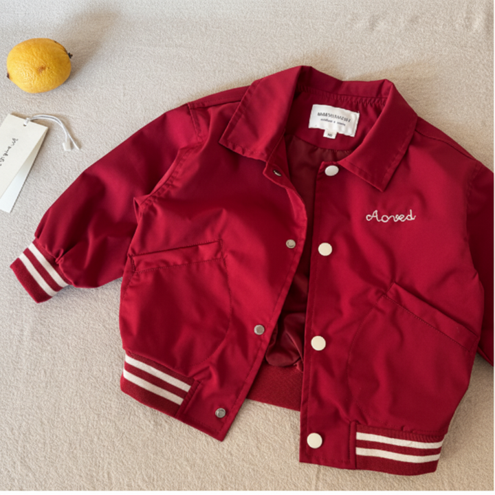 Red baseball jacket with a fold-over collar, light-colored snaps, and embroidered chest detail