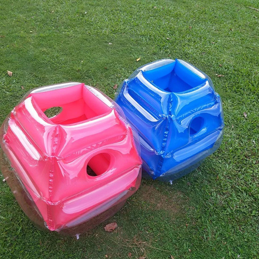 Red and blue inflatable play balls on grass with open tops visible