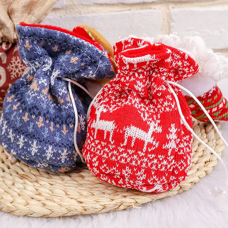 Close-up of blue snowflake and red reindeer-pattern gift bags with white drawstrings.