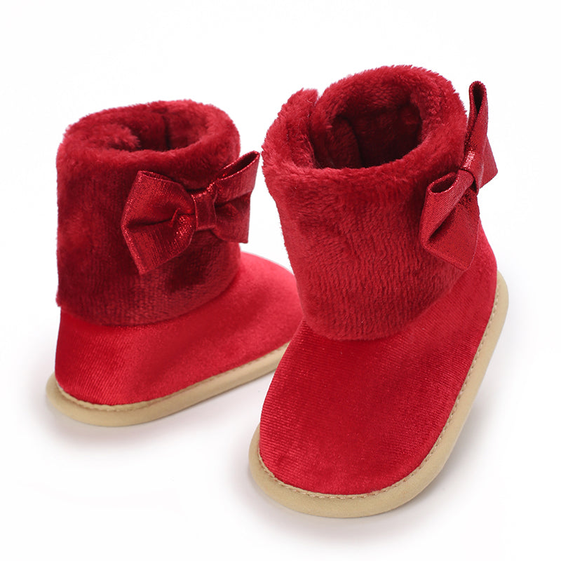 Red baby boots with plush cuffs, side bows and light-colored soles