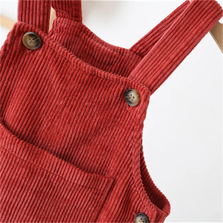 Red corduroy overall bib pocket, ribbed fabric, and button details