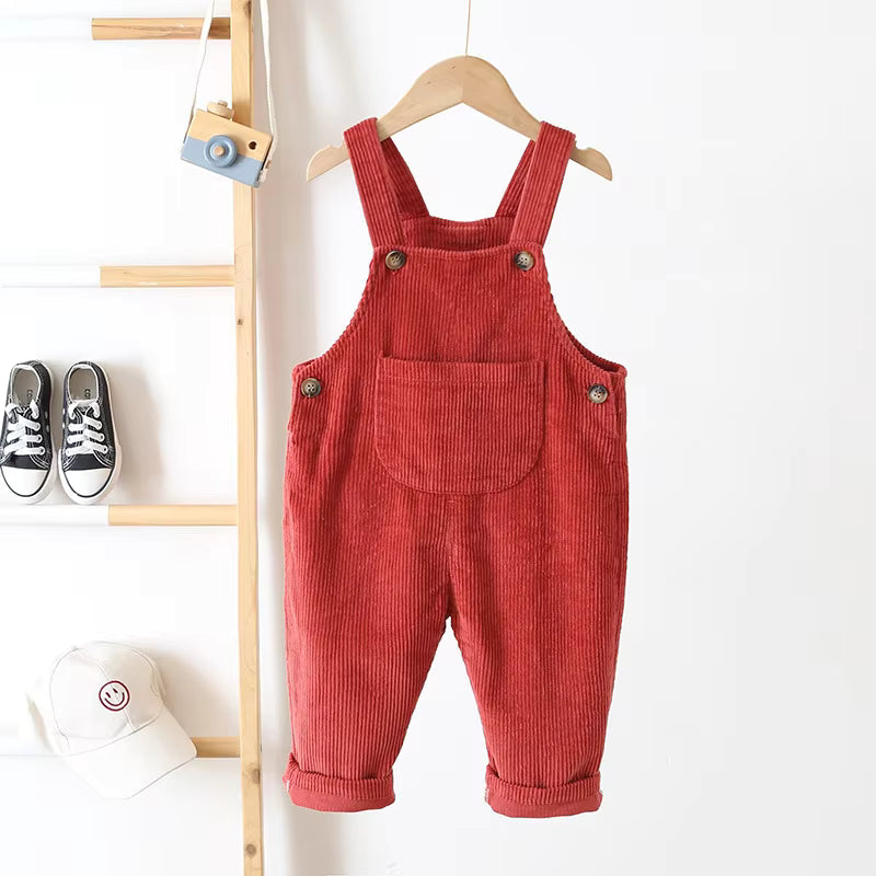 Red corduroy overalls on a hanger, showing the front pocket and cuffed legs