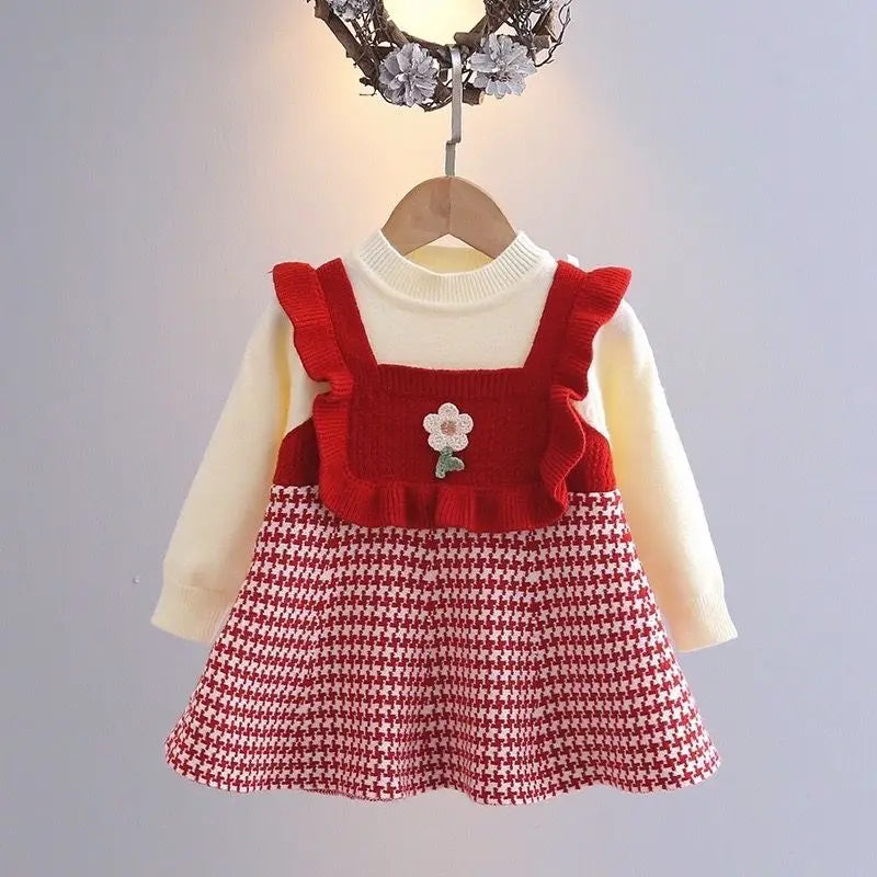 Red dress on a hanger with cream long sleeves and a flower-accented ruffled bodice