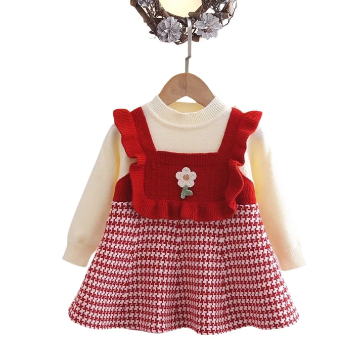 Red long-sleeve dress with a flower detail, ruffled bodice, and red-and-cream houndstooth skirt