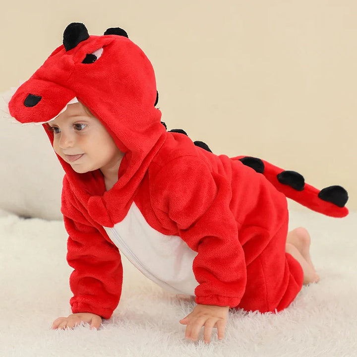 Baby wearing a red dragon onesie with a white belly and black tail spikes