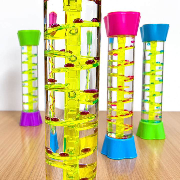 Close-up of red droplets on a yellow spiral track with other sensory tubes behind