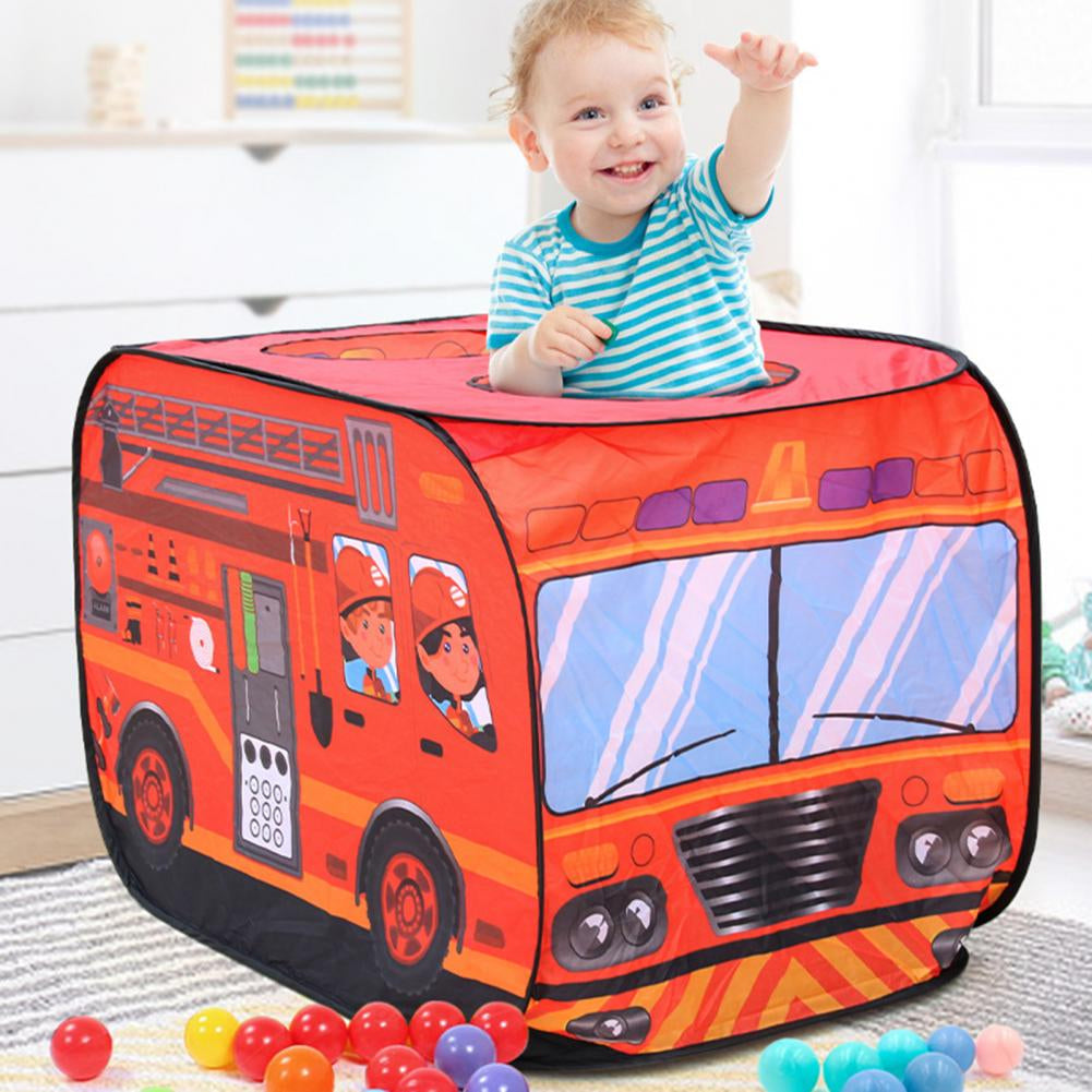 Child reaching up through a round roof opening in the red fire engine play tent