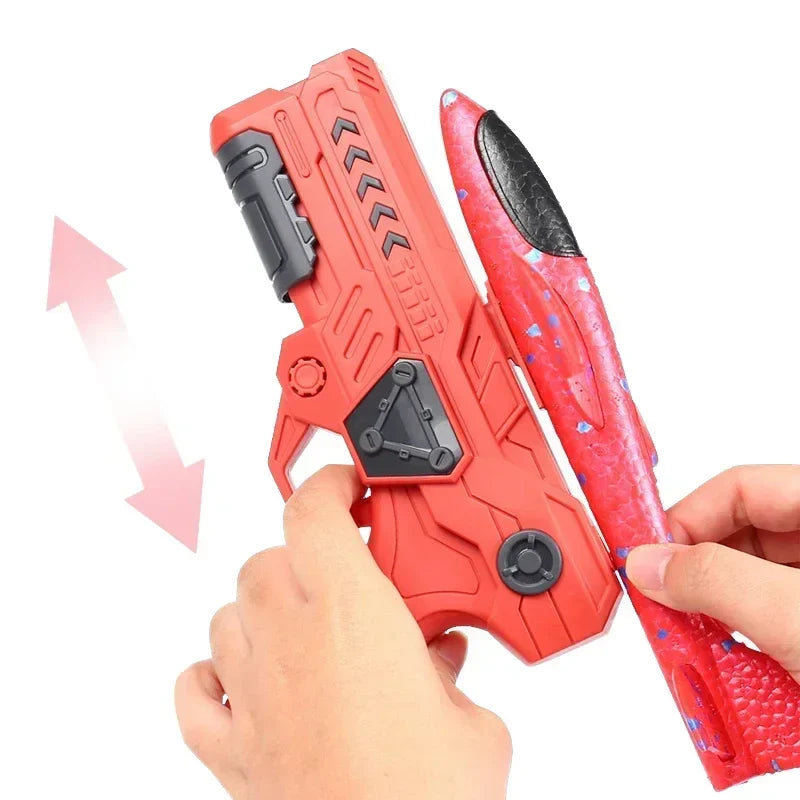 Hands positioning a red foam airplane along a red launcher