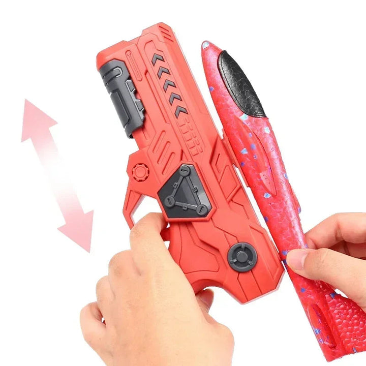 Hands positioning a red foam airplane along a red launcher