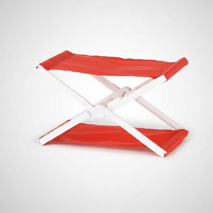 Red folding headrest with a white cross-frame, shown open