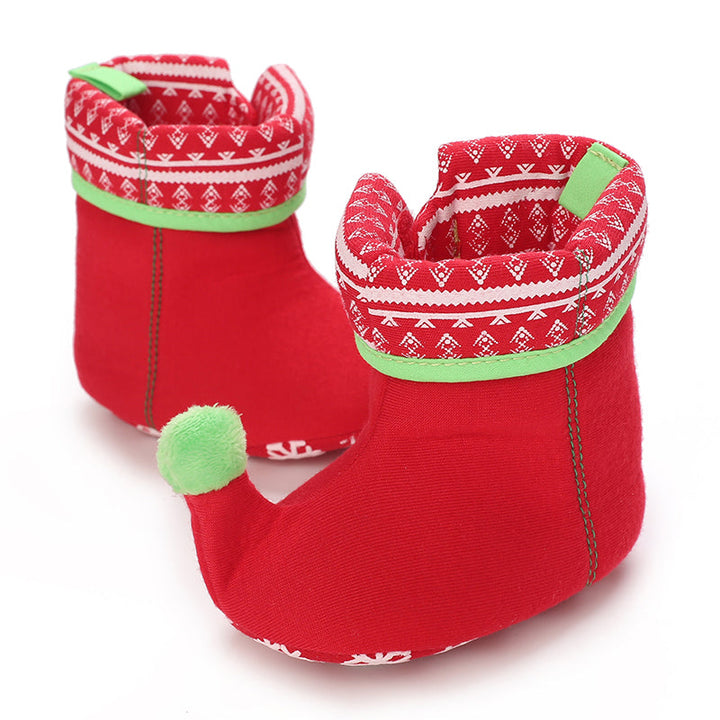 Red baby booties with green trim, patterned cuffs and a green pom-pom