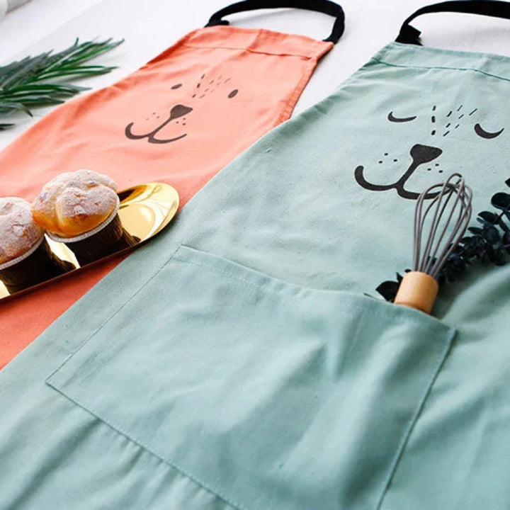Red and green bear aprons with front pockets shown beside baked treats