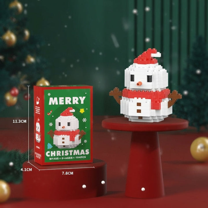 Mini snowman block figure wearing a red hat and scarf beside its box