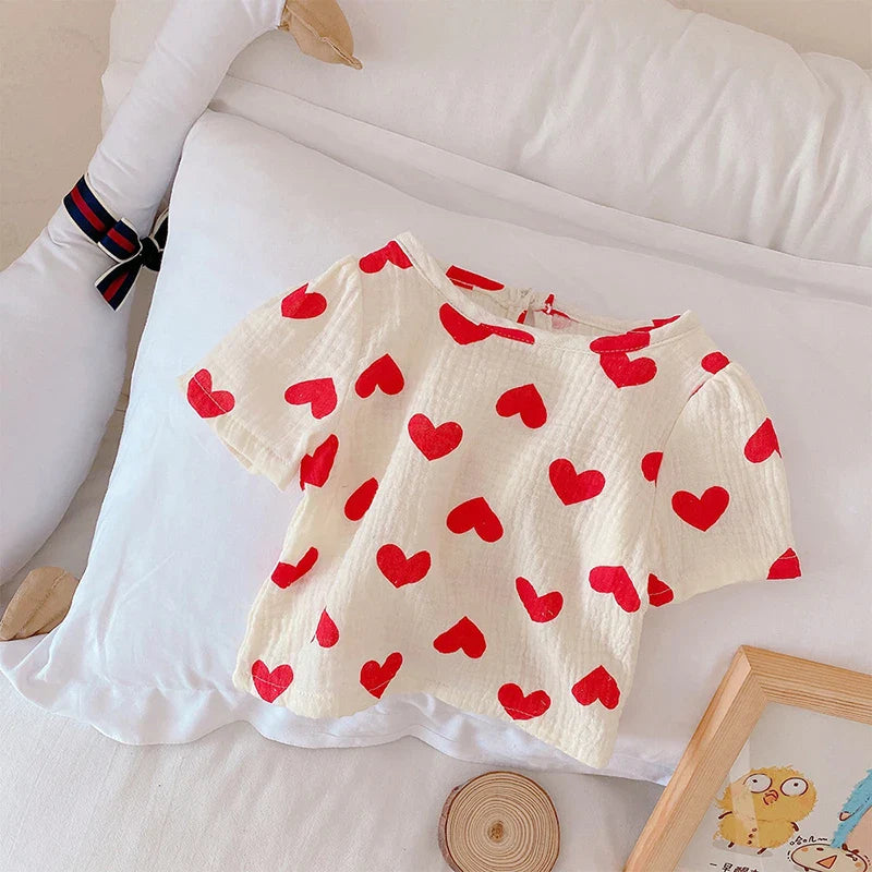 Short-sleeve cotton top with red hearts and a rounded neckline
