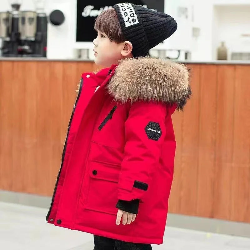 Child wearing a red winter coat with fluffy hood trim, viewed from the side