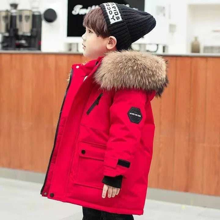 Child wearing a red winter coat with fluffy hood trim, viewed from the side