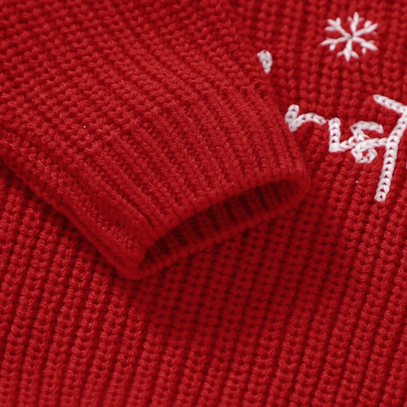 Close-up of the ribbed sleeve cuff and knit fabric on the red Christmas sweater.