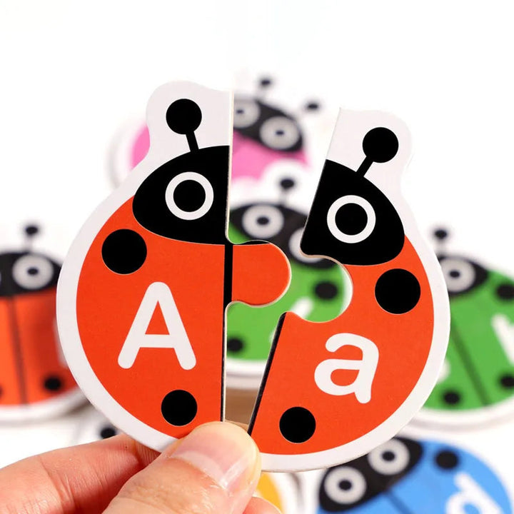 Hands holding a red wooden ladybug puzzle with uppercase A and lowercase a